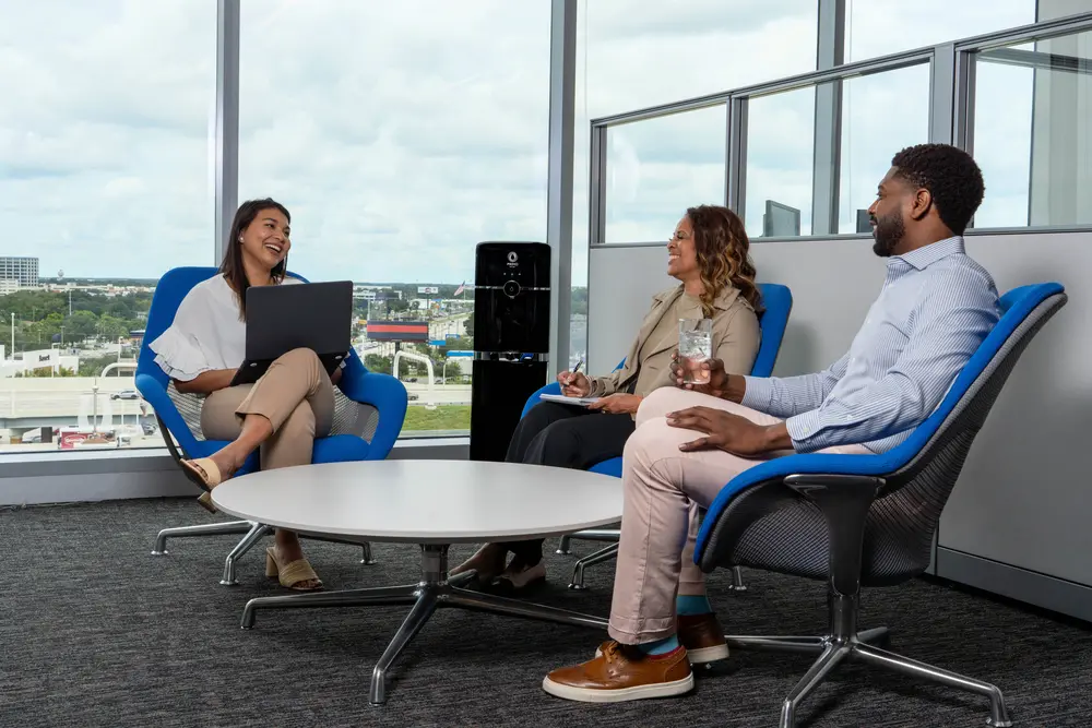 Employees enjoying a Primo Water Dispenser in an office