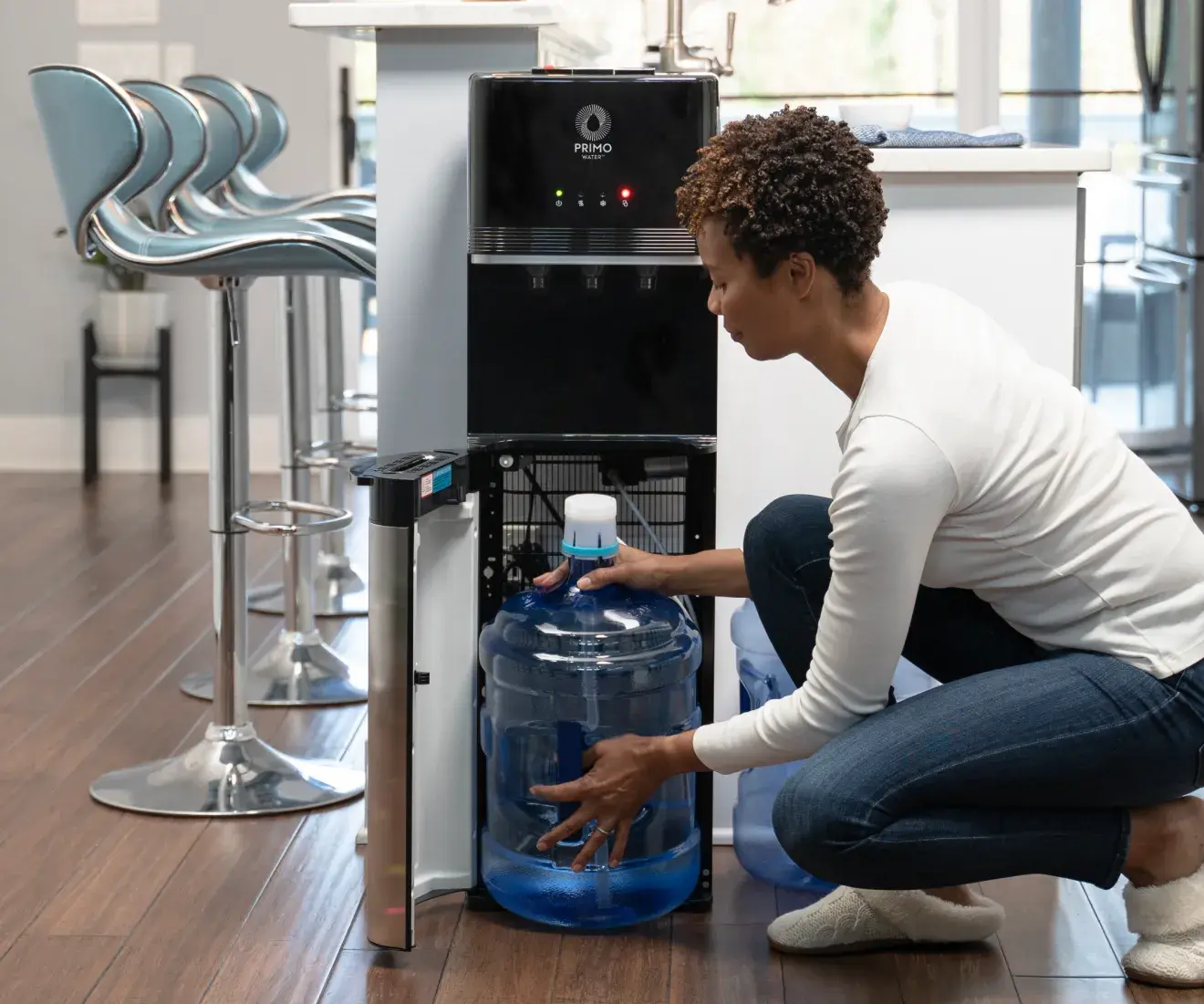 woman placing water jug in bottom loading water dispenser