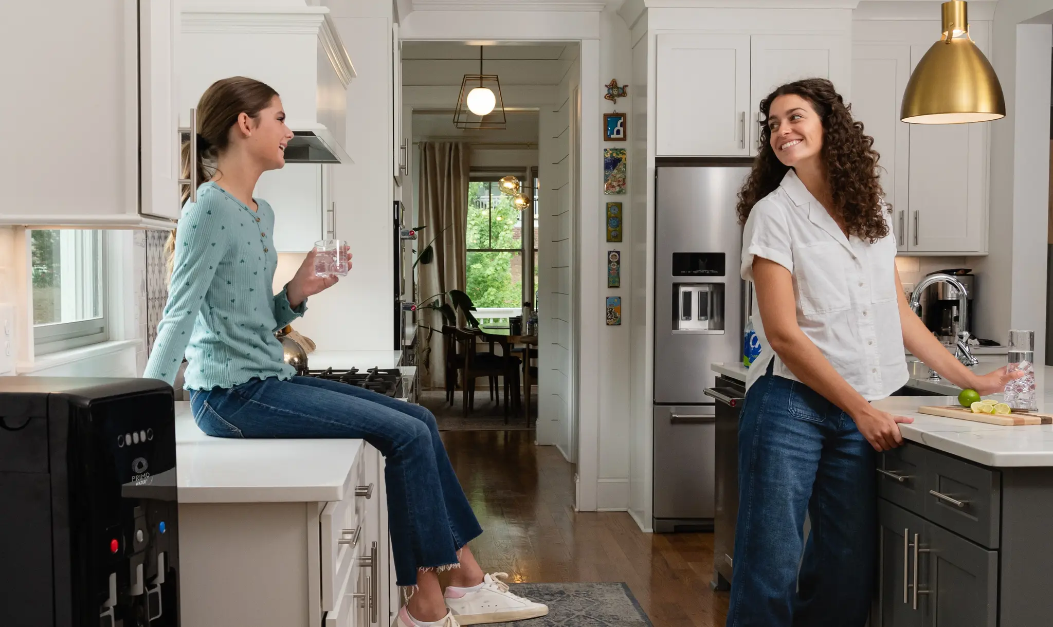 A mother and daughter enjoying water from their Primo Water Dispenser
